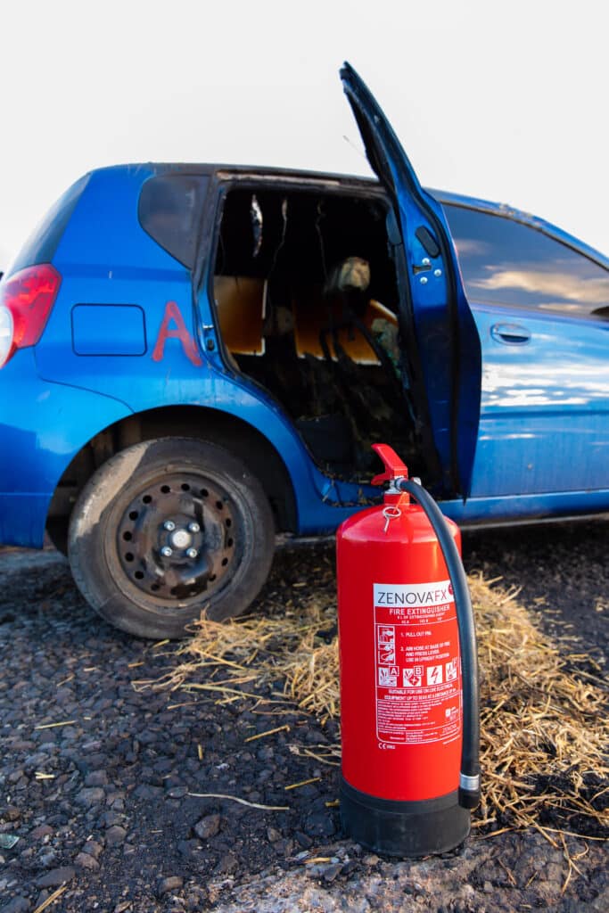 Blue car in field with all in one fire extinguisher